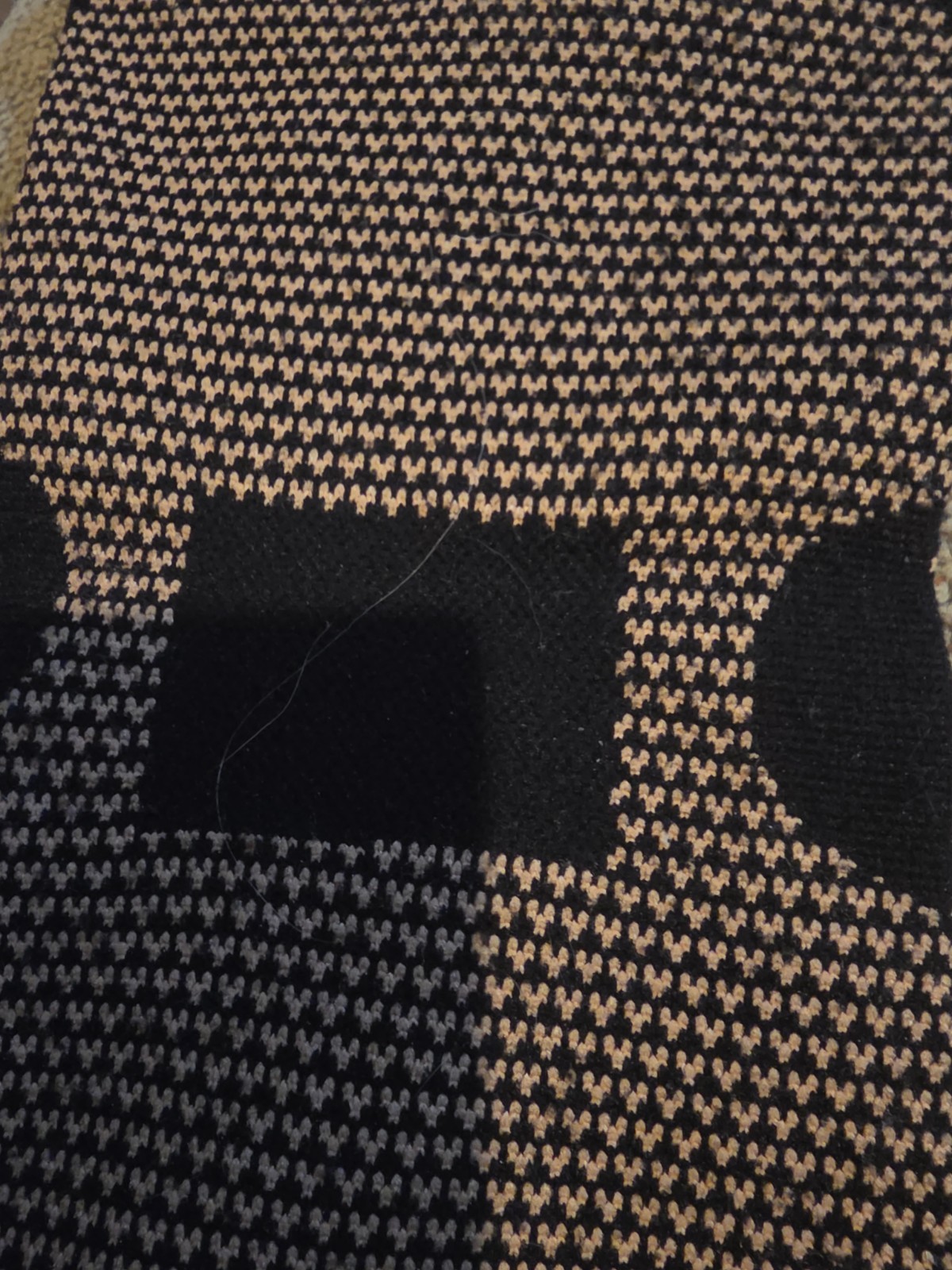 black copper compression knee sleeve featuring a textured circular knit pattern